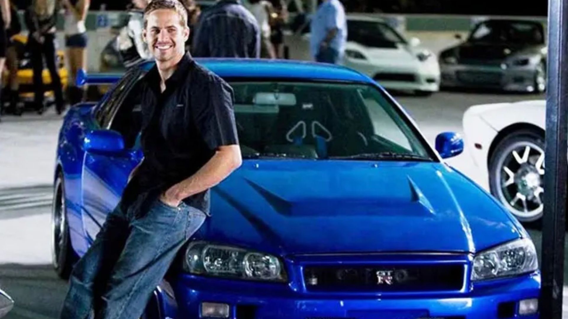 paul walker recargado en un auto nissan azul en rápidos y furiosos