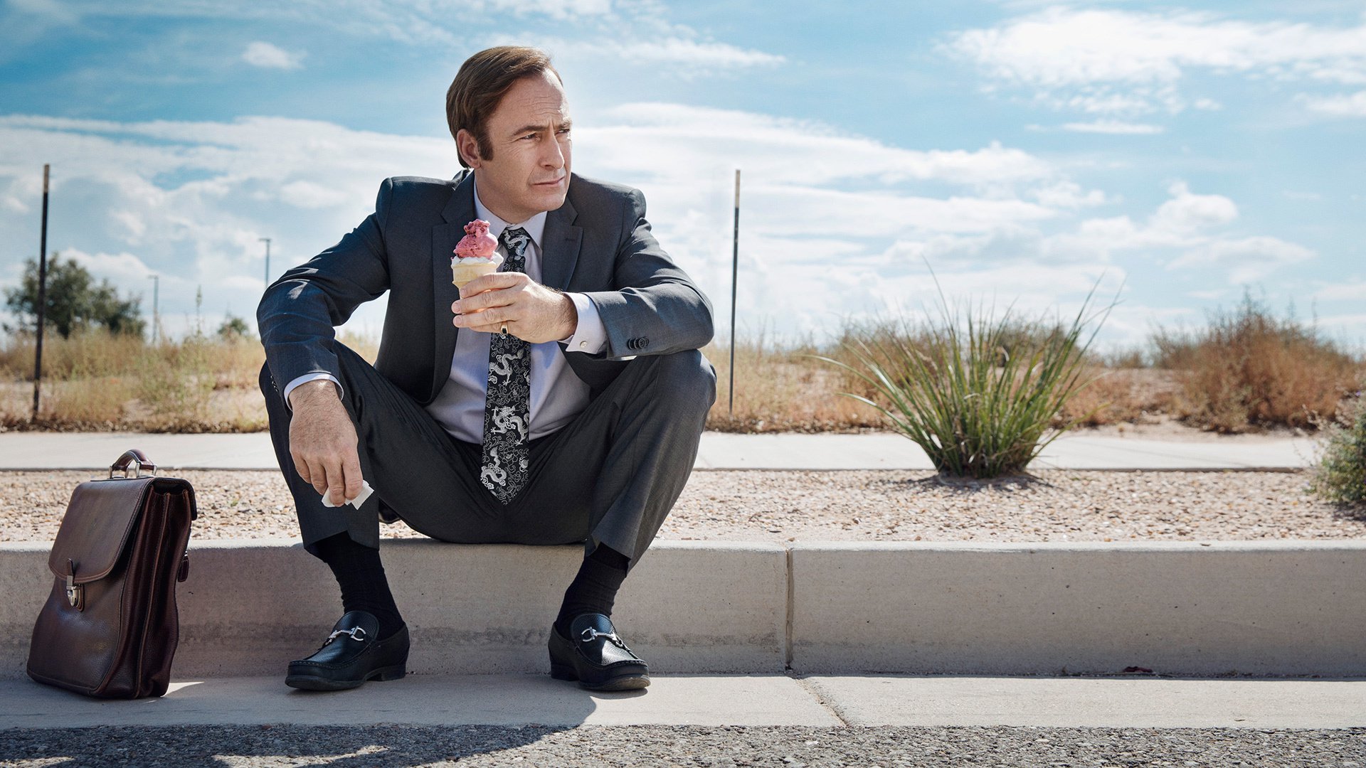 Bob Odenkirk sentado en la banqueta en promocional de Better Call Saul