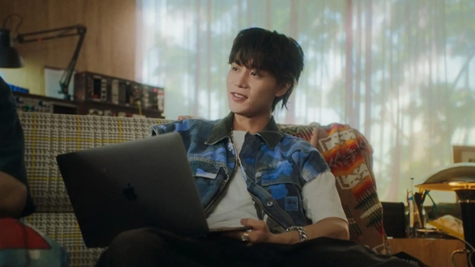 Taeil en un sillón con computadora
